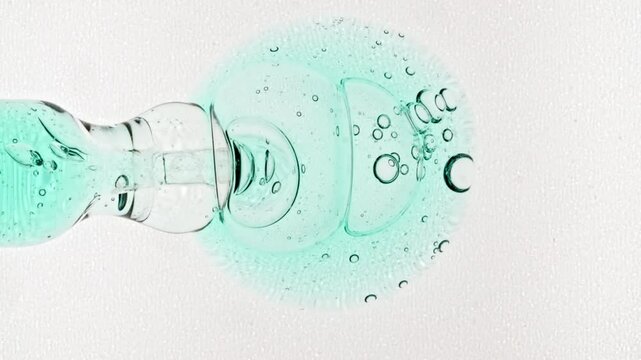 Liquid fluid pink gel or serum in pipette drips on a white surface. Dropper for cosmetic fluid with bubbles from above.The medicine concept, health care, treatment. Slow motion. High quality 4k