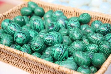 Colorful green decorative stones arranged in a woven basket