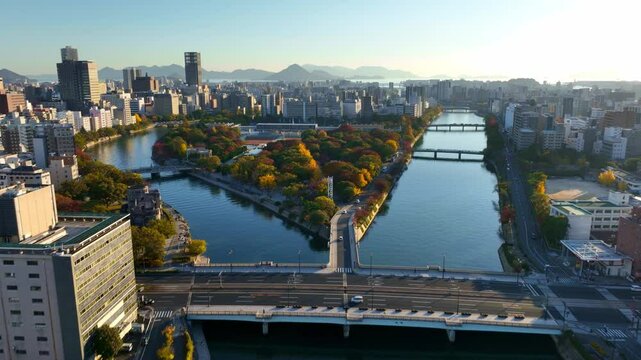 flying above downtown Hiroshima, aerial view of Hiroshima Peace park, establishing shot of Motoyasu river in Hiroshima, travel in Japanese city of Hiroshima