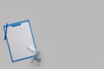 Clipboard with pen and gynecological speculum on grey background