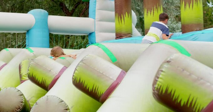 Kids climbing on inflatable obstacle course outdoors