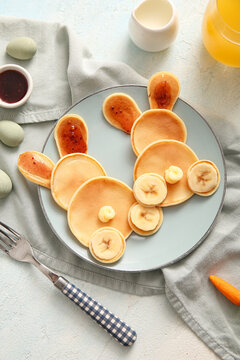 Naklejki Funny Easter bunny pancakes with painted eggs on light blue background