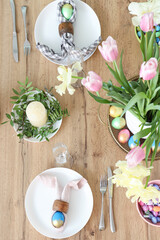 Beautiful table setting, painted eggs, cutlery and vase of flowers