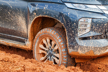 A tire stuck in the mud on a dirt road on a village road. Off-road trips are loved by adventurers © Sony Herdiana