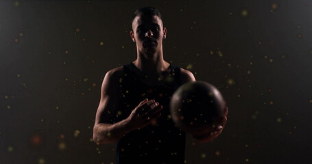 Image of moving spots over caucasian male basketball player holding basketball