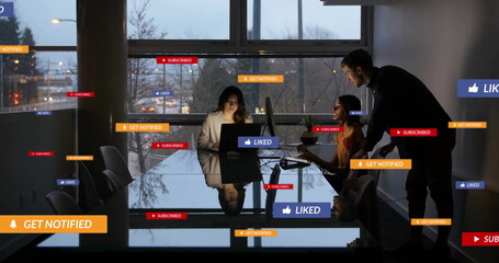 Image of media icons over diverse colleagues discussing work in office