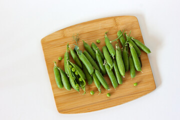 Fresh green peas on wooden cutting board: healthy eating concept