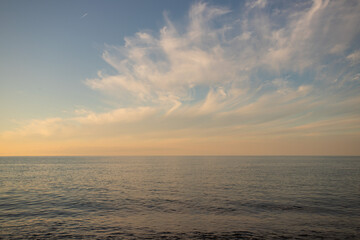 Sunset at sea, summer seascape with golden sunlight, water and skyline create romantic scene.
