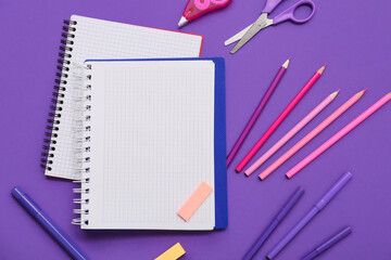 Notebook, pencils and scissors on purple background. Top view