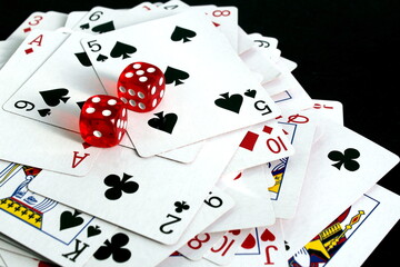 On a black background lies a deck of cards with dice.