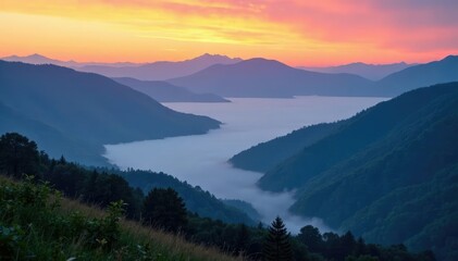 Fototapeta premium Majestic mountains rise above a valley covered in mist at sunrise, landscape, fog, clouds