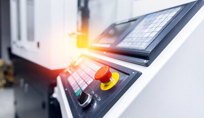 Close-up of industrial cnc machine control panel with illuminated buttons and screen