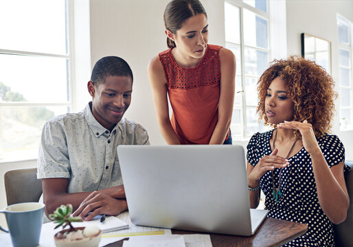 Discussion, laptop and people in startup for graphic design, meeting and collaboration. Brainstorming, talking or creative strategist in workplace for project, planning or teamwork in small business