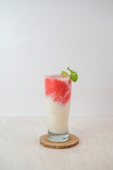 Layered Strawberry And Soursop Juice In A Tall Glass With Mint Garnish, Showing Red And White Layers With A Smooth Texture On A Minimalist Background.
