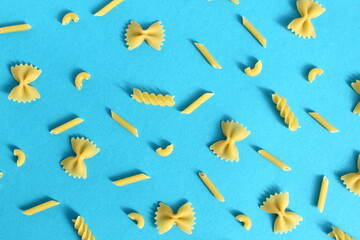 Abstract texture of different pasta on a blue background.
