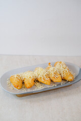 Golden Brown Fried Bananas Generously Topped With Grated Cheese Offering A Rich, Indulgent, And Comforting Dessert Experience.