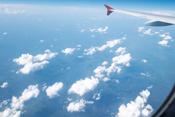 Fototapeta premium View from window of the plane above expanse of fluffy white clouds