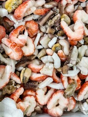 Fresh seafood assortment featuring shrimp and clam varieties in a market setting
