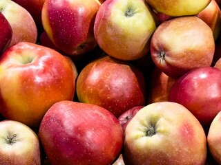 Fresh red apples piled together at a local market showcasing vibrant colors and natural shine