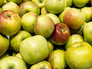 Fresh apples displayed in a vibrant market environment, showcasing a variety of colors and textures