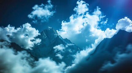 Snow capped mountain peeks through the cloud cover under a blue sky at dusk, with a blue colour grade.