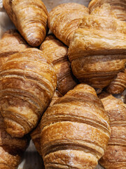 Freshly baked croissants displayed at a local bakery in the morning sunlight