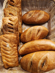 Freshly baked bread assortment displayed in a woven basket at a local bakery