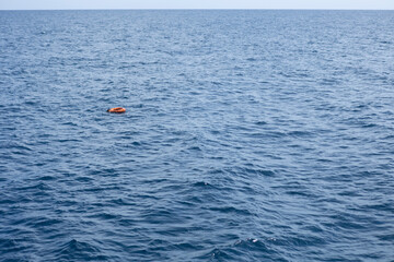 Orange lifebuoy floating on calm blue sea in marsa alam, egypt
