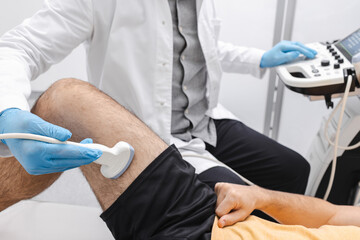 Leg venous ultrasound . Doctor sonographer examines veins condition of upper leg of man with pain