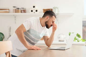Young man feeling unwell in kitchen