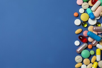 Colorfull pills on blue background, top view