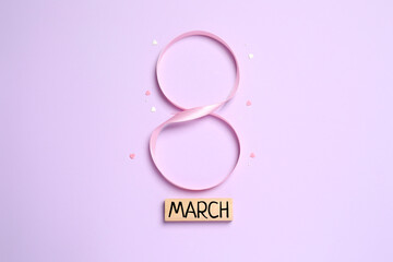 8 March, International Women's Day. Figure eight made of pink ribbon on a color background. Space for text
