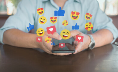 Social media engagement and digital communication concept. A person using a smartphone with floating like, love, and emoji reactions. Online interaction, content marketing, and social networking