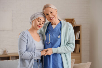Young woman after chemotherapy with nurse hugging at home. Brain cancer concept