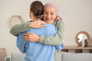 Mature woman after chemotherapy with nurse hugging at home. Brain cancer concept