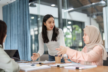 Women discussing financial strategies in a modern office setting, emphasizing teamwork and collaboration.