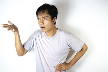 Asian teenager in white t-shirt is posing confusedly facing right