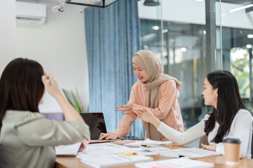 Fototapeta premium Diverse female professionals leading a meeting in a modern office.