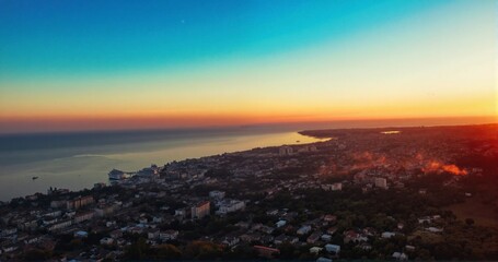 A beautiful sunset over a city with a large body of water in the background