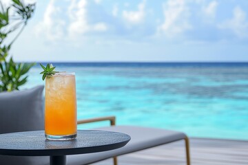 Refreshing cocktail on a lounge table with a stunning ocean view at sunset
