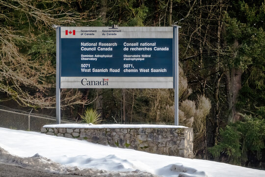 Victoria, British Columbia, Canada. Feb 21, 2025. A bilingual sign for the Dominion Astrophysical Observatory, part of the National Research Council Canada, is displayed against a natural, snowy bg.