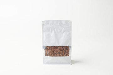 Clear Packaging With Roasted Coffee Beans Displayed Against a Minimalist Background