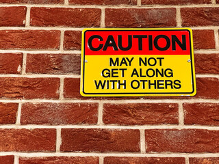 Obraz premium Caution sign displayed on a brick wall with an attention-grabbing message