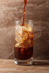 Black iced coffee on a ceramic table.