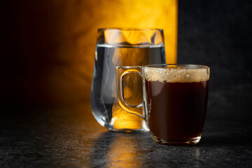 Espresso and glass of cold water on a black background.
