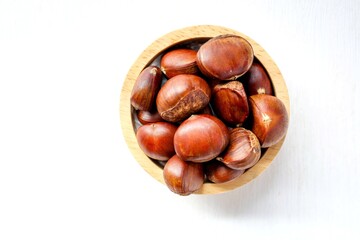 Obraz premium chestnut in wooden bowl on white background