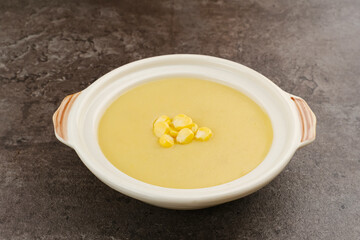 Creamy corn soup in ceramic bowl on the table. Vegetarian food
