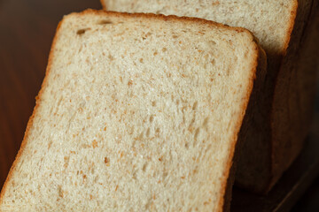 ライ麦と全粒粉を配合した食パンをスライスした断面　木製テーブルの背景