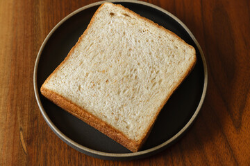 ライ麦と全粒粉を配合した食パンをスライスした断面　木製テーブルの背景