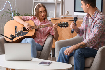 Young couple recording podcast in studio